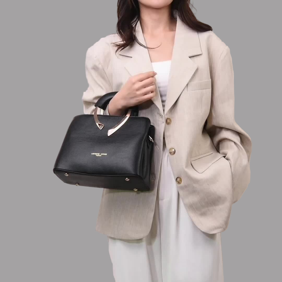 Person holding a black handbag against a plain background