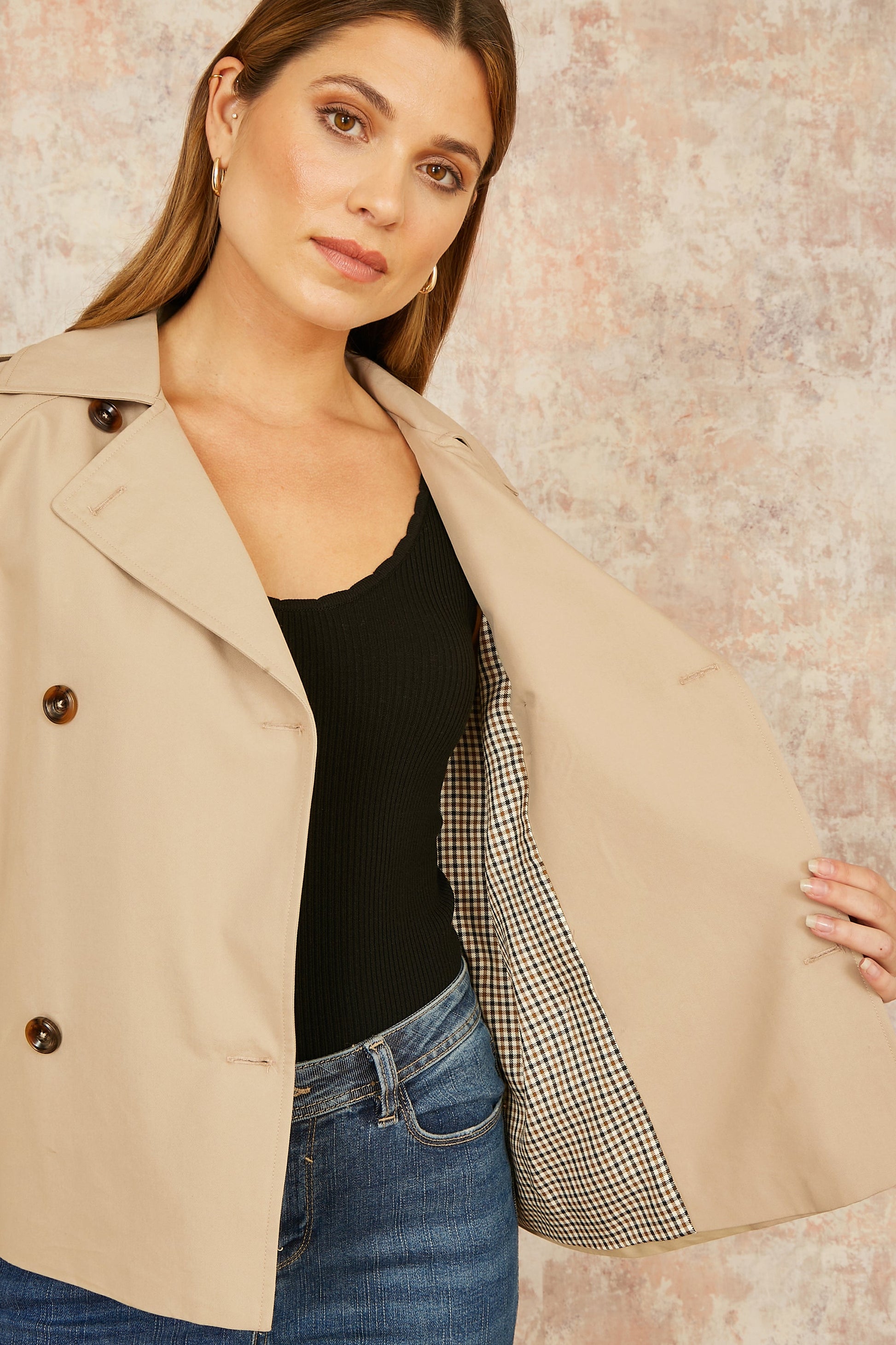 Side view of beige cropped trench jacket with functional pockets and belted waist detail