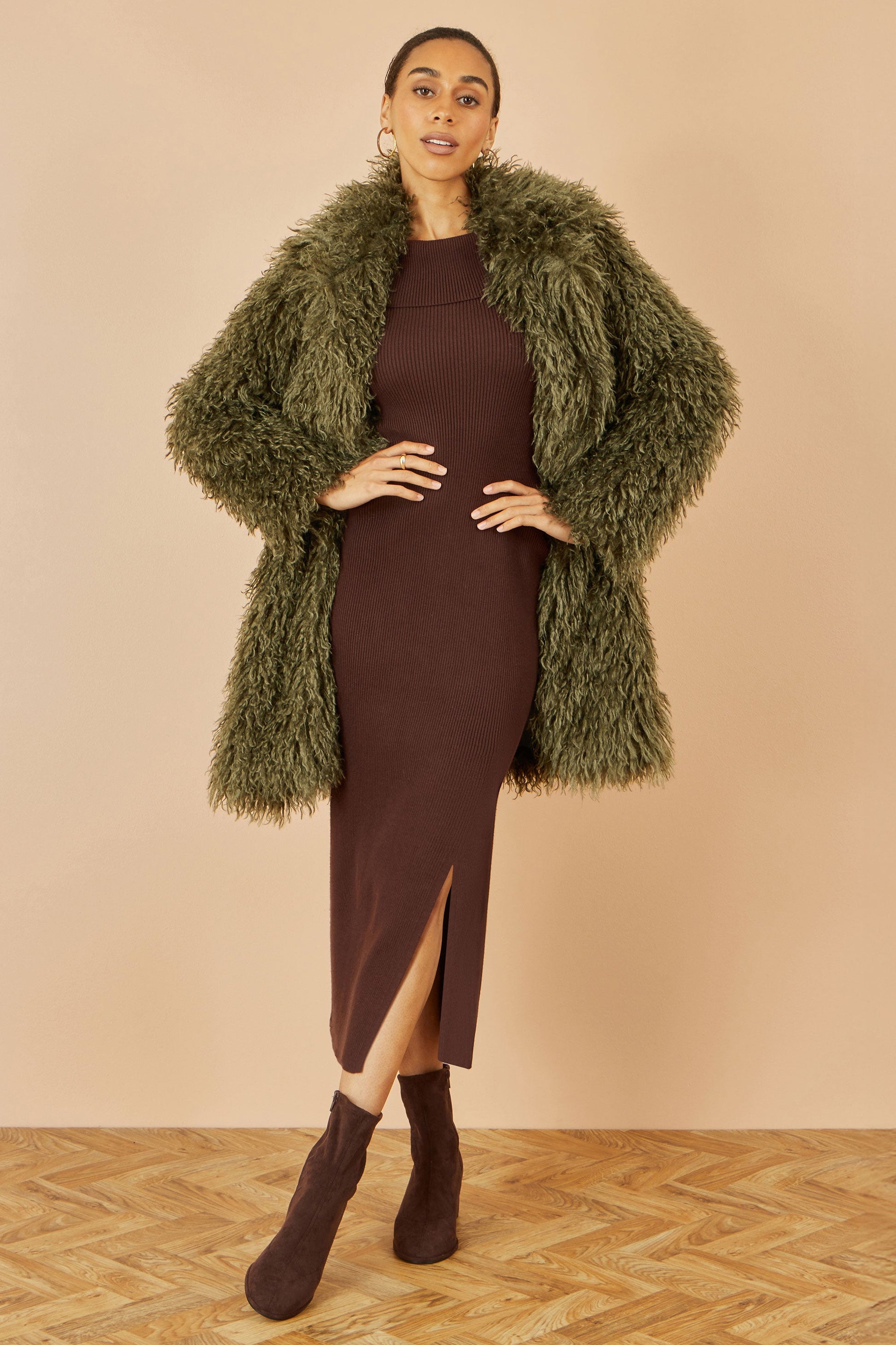 Close-up of fluffy long hair faux fur texture on green Yumi coat