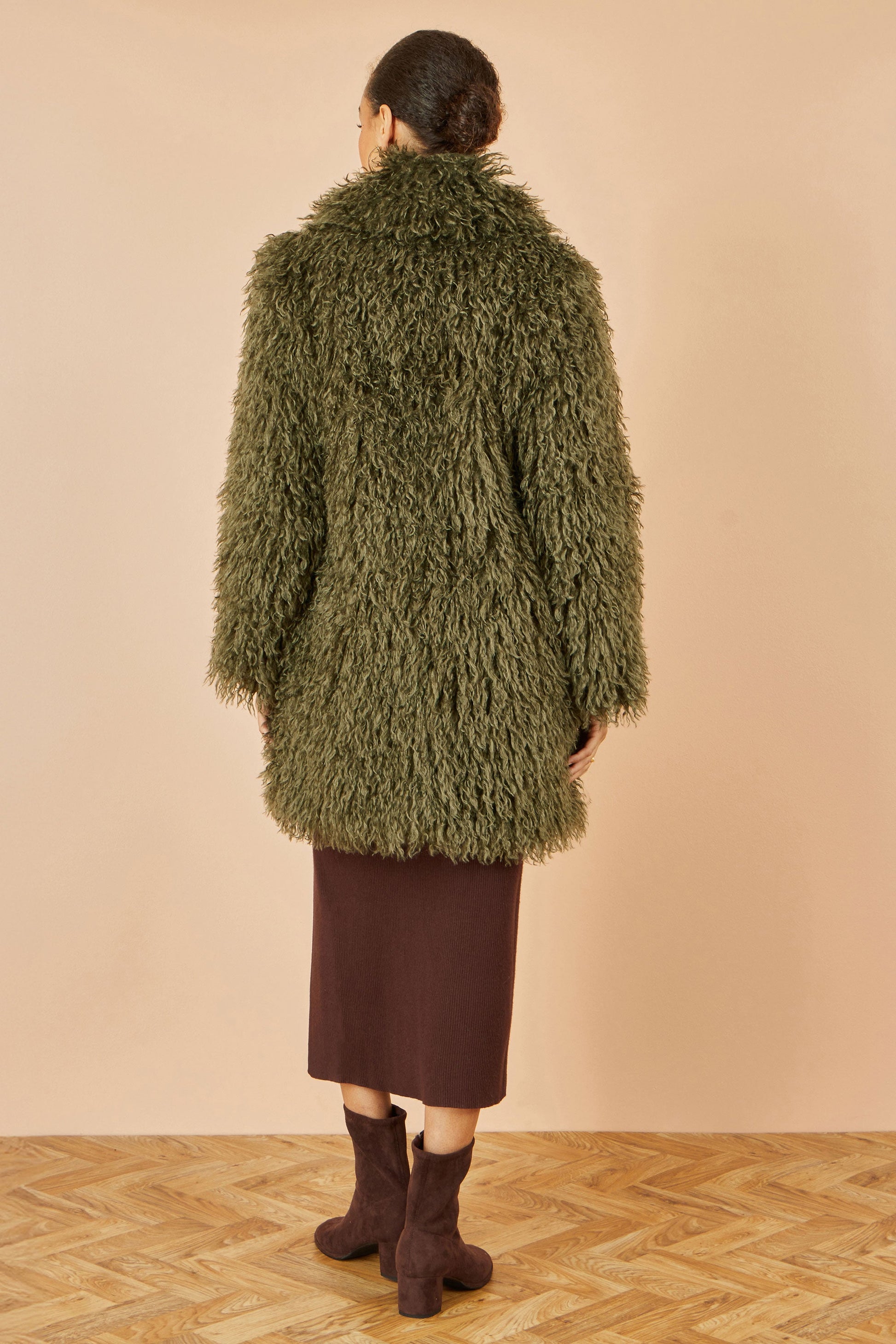 Back view of Yumi green luxe faux fur coat showing relaxed overcoat fit
