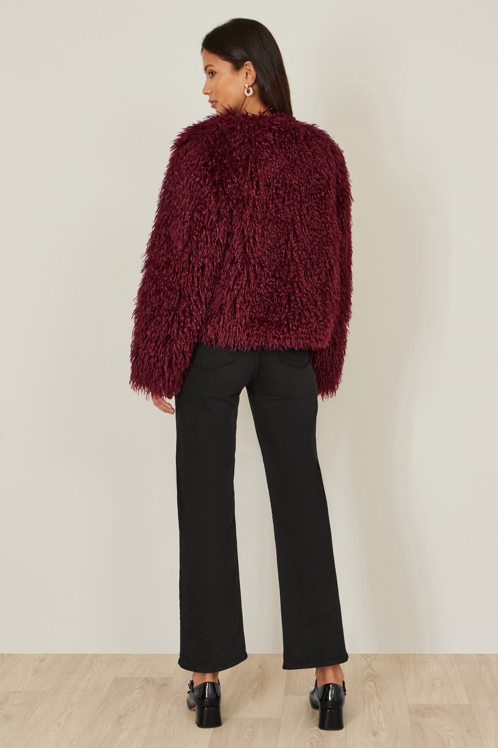 Back view of burgundy cropped faux fur coat showing 82cm length and silhouette