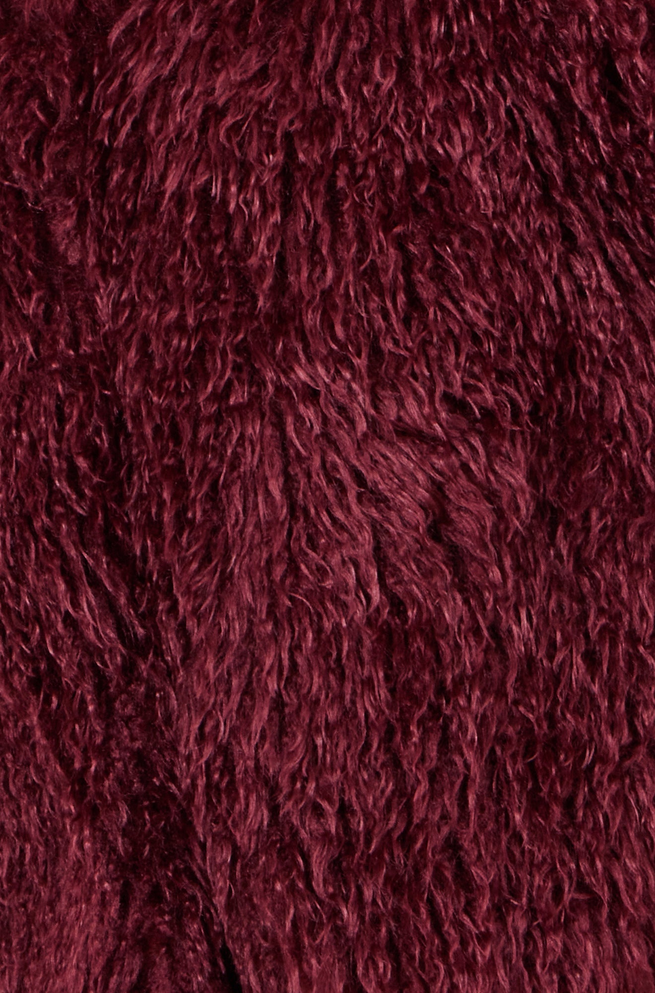 Close up detail of burgundy faux fur coat sleeves showing extra fluffy texture