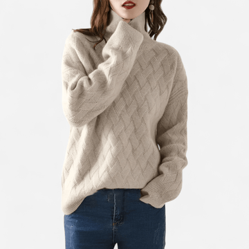 Person wearing a Carmel cable knit sweater on a white background