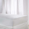 White waterproof terry towel mattress protector on a double bed