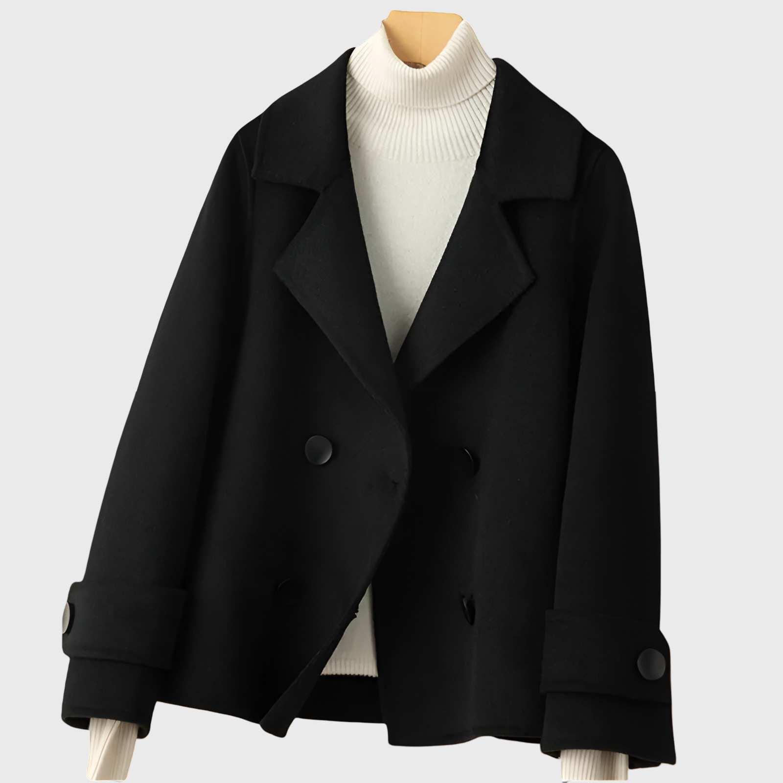 Black coat on a mannequin with a white turtleneck sweater underneath against a light gray background