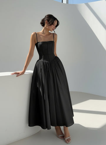 Woman in a black dress standing in a garden setting