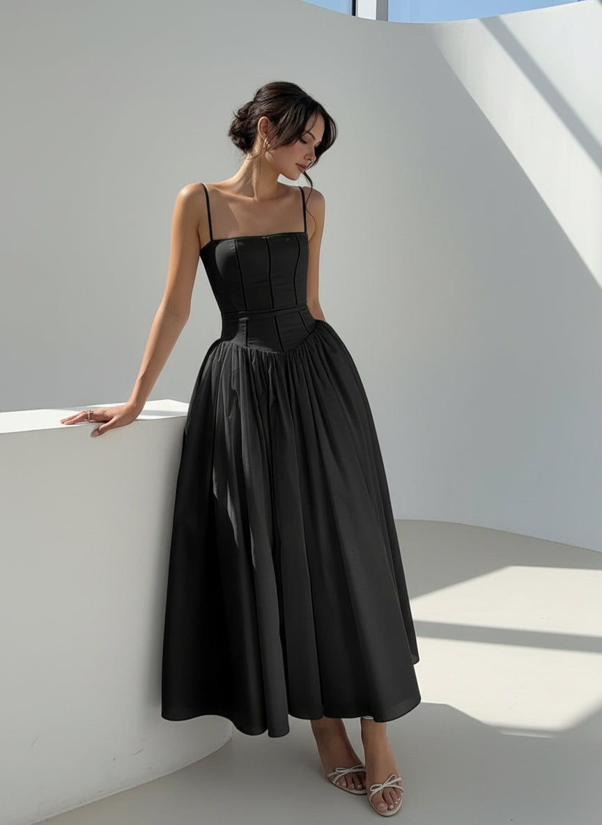 Woman in a black dress standing in a garden setting